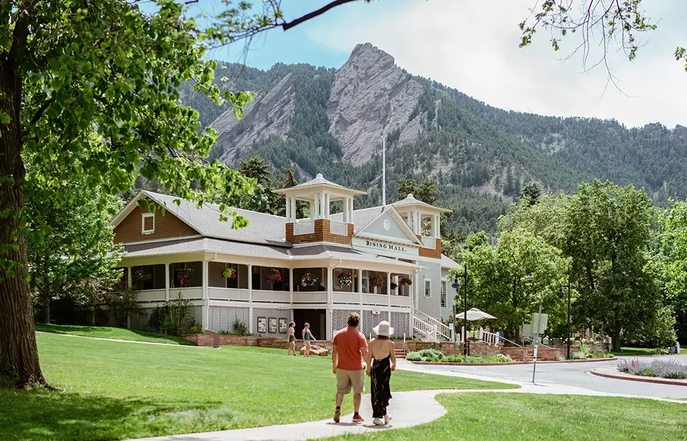 Several small groups walking along scenic trails at Chautauqua Park with open natural surroundings.