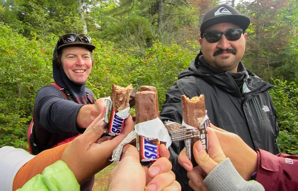 Group of people holding energy bars in a circle.