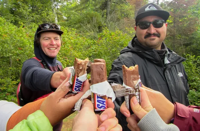 sal.webp Group of people holding energy bars in a circle.